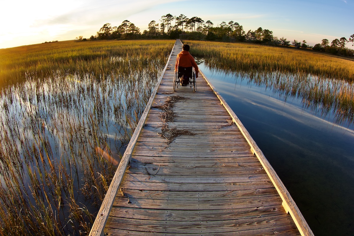 man in wheelchair on boardwalk