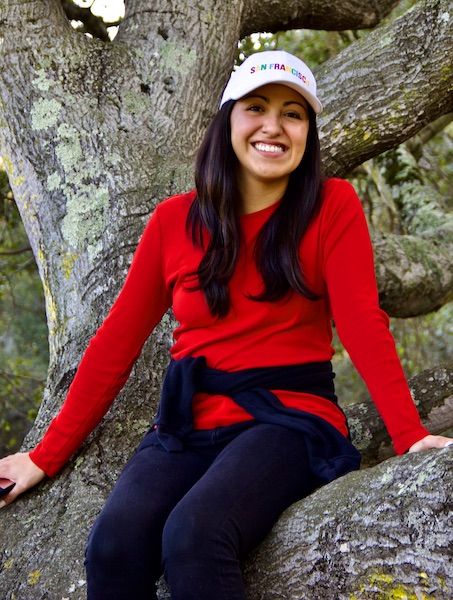 young woman sitting in tree