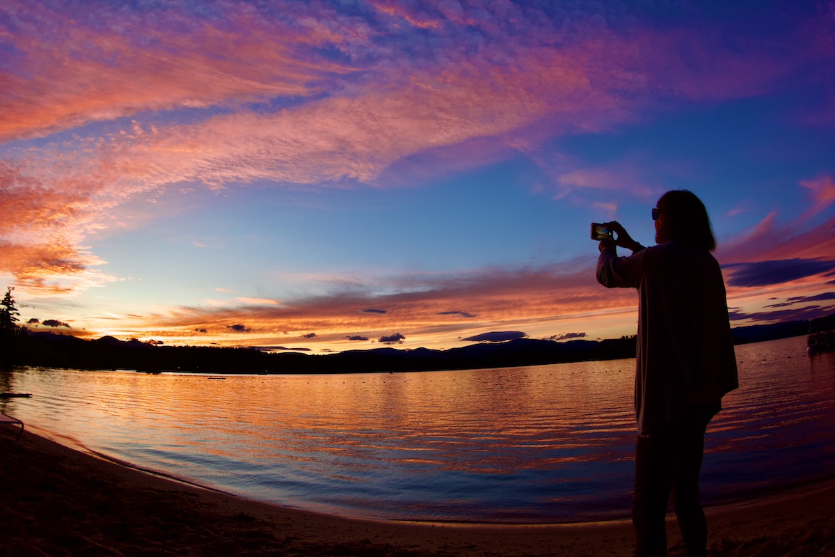 woman photographing sunset