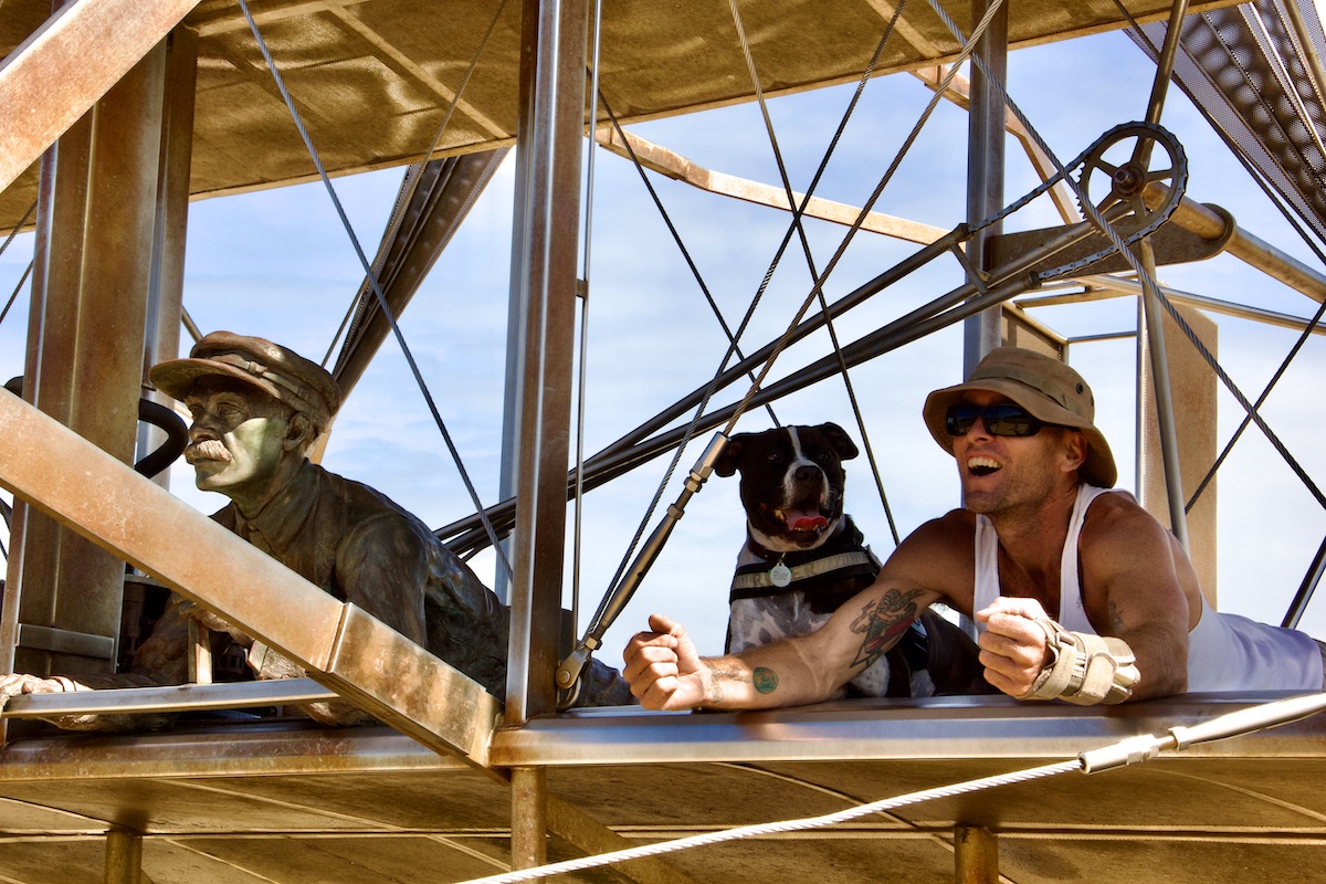 man and dog of Wright brother's plane