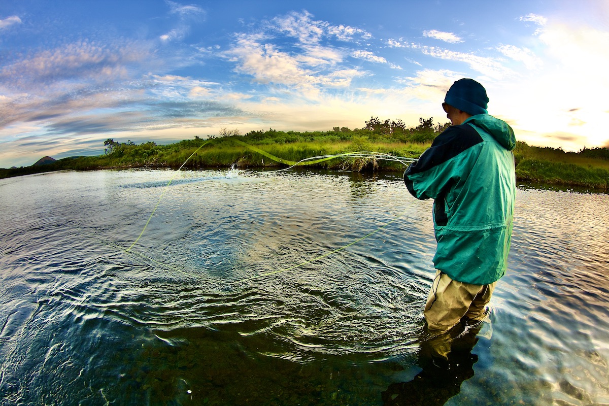 fly fisher fighting fish