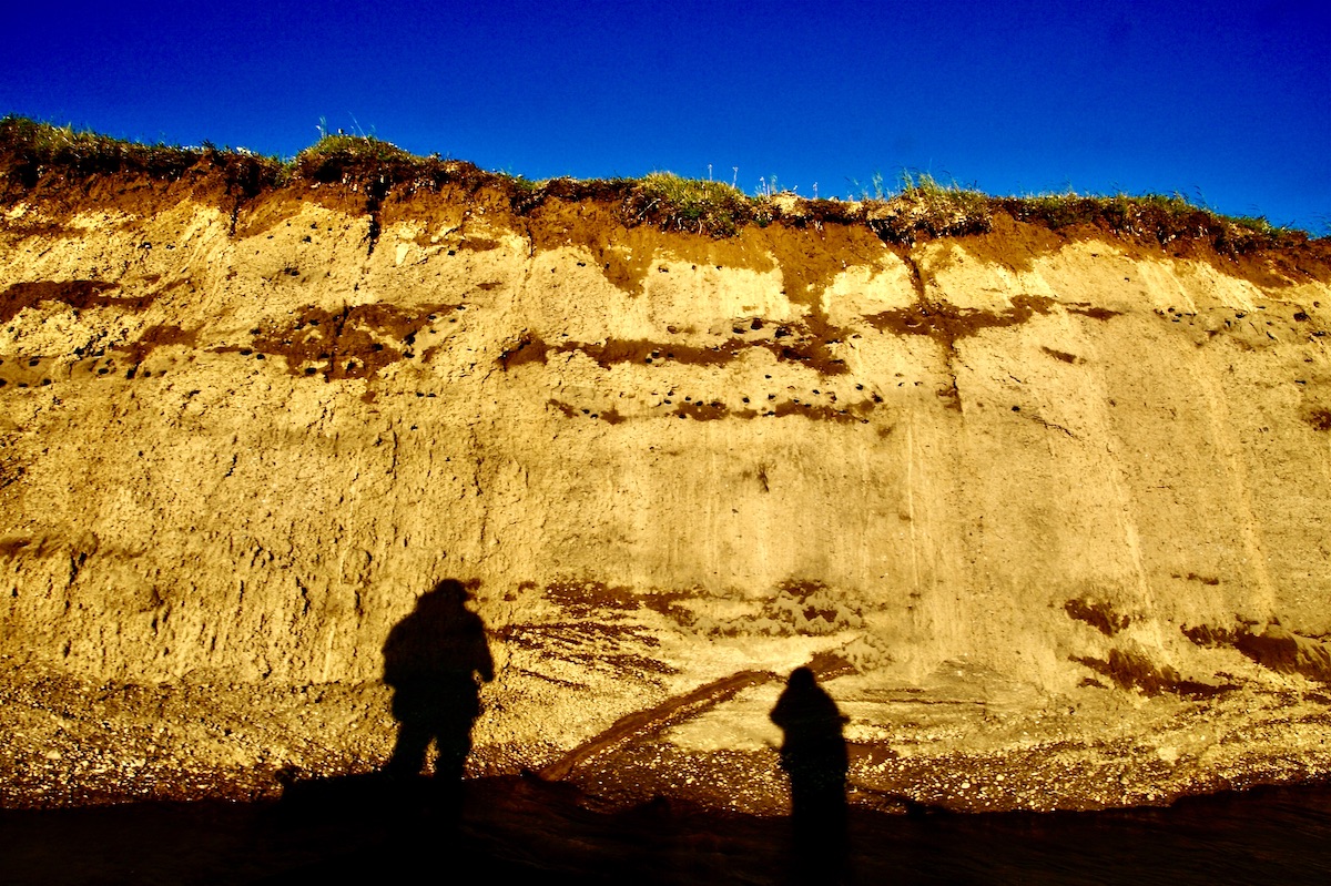 two men's shadows on a cliff