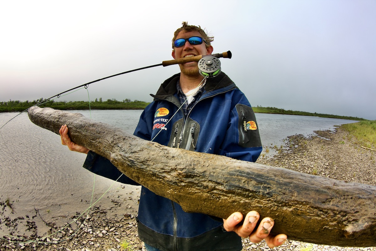 fly fisher with a small log