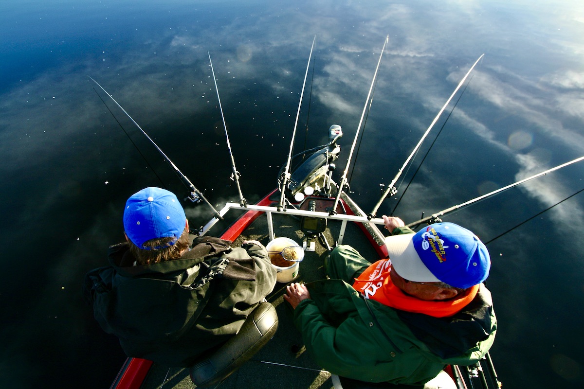 two fishermen with many fishing rods