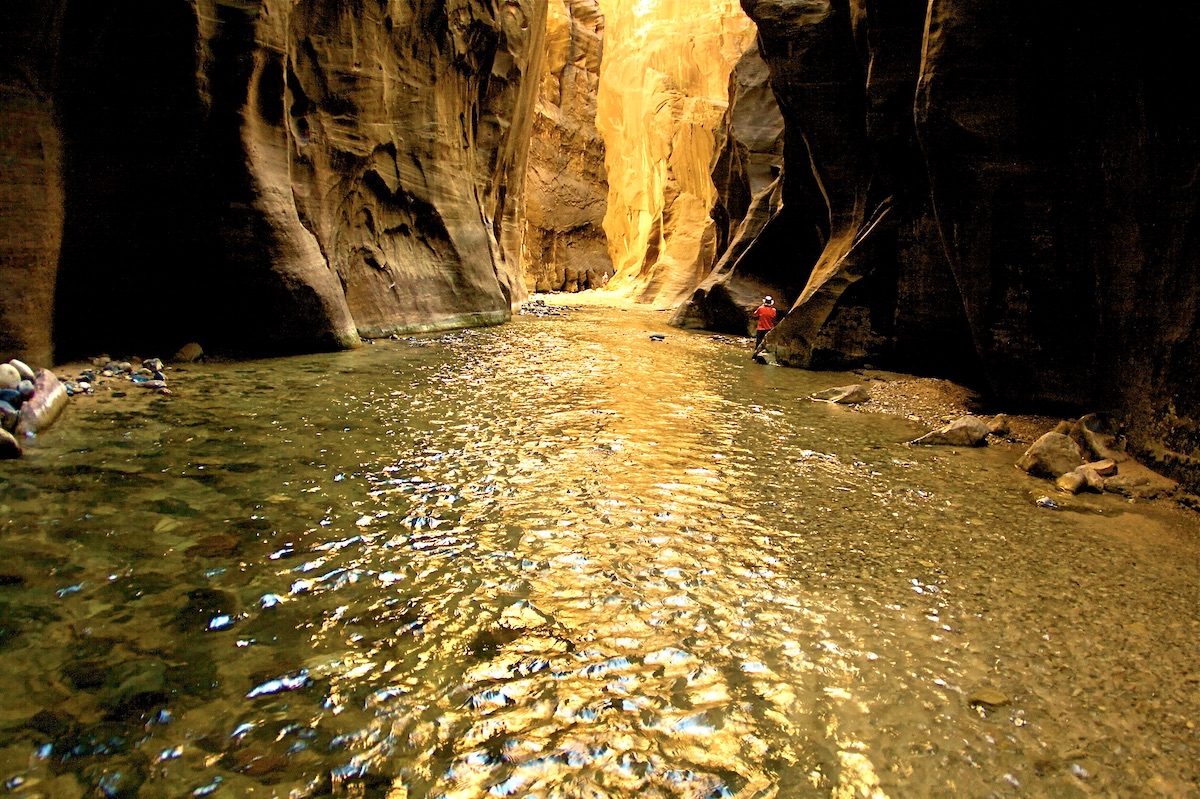 hiker in a river in a canyon